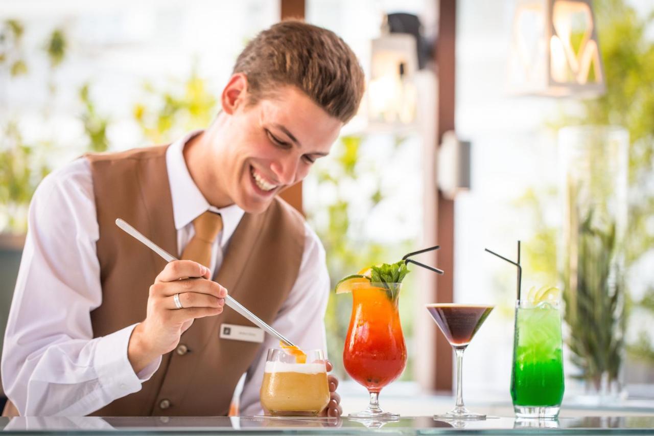 Epic Sana Lisboa Hotel Luaran gambar A bartender using a digital tablet